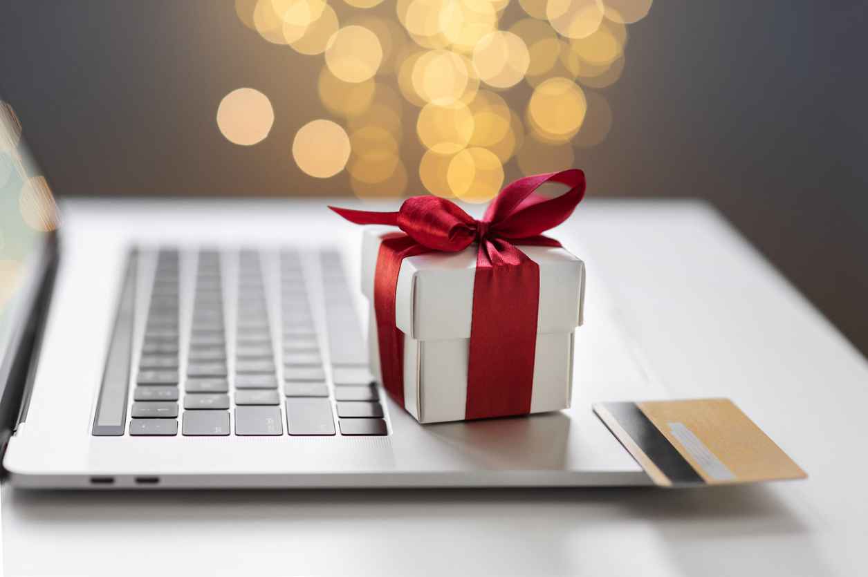 Online shopping during holidays. Christmas gift and credit card on laptop