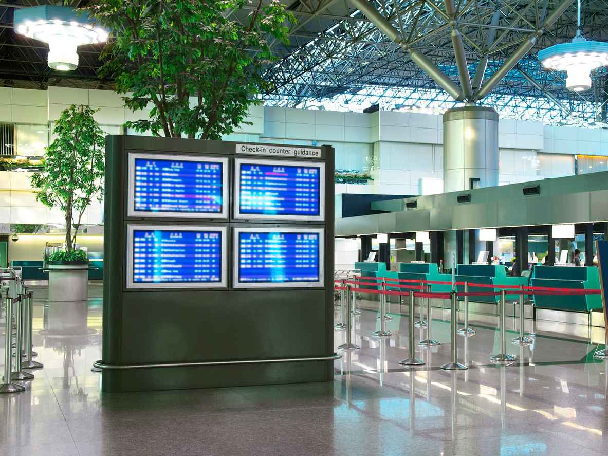 Flight schedule display screens and check in counter in airport