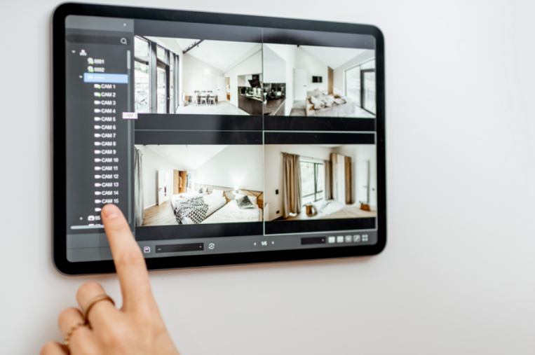 A person using a touchscreen camera monitor at home