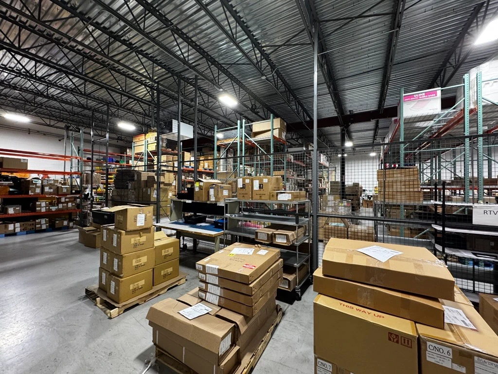 The FORTEC US warehouse in Ronkonkoma, New York: pallets of boxed displays and parts ready to ship, with steel racking under a high ceiling